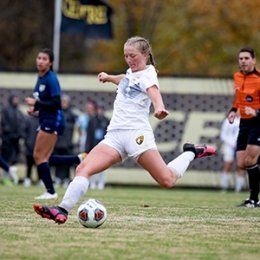 Centre student athlete kicking a soccer ball