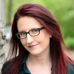 lady with shoulder length red hair with glasses wearing black top