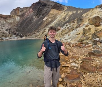 Student standing in front of inactive volcano in New Zealand on study abroad trip