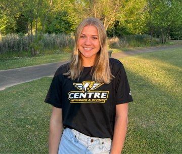 student wearing Centre swiming and diving shirt and smiling at photographer