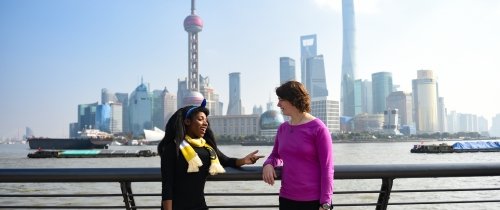 Students standing in front of Shanghai skyline during the day