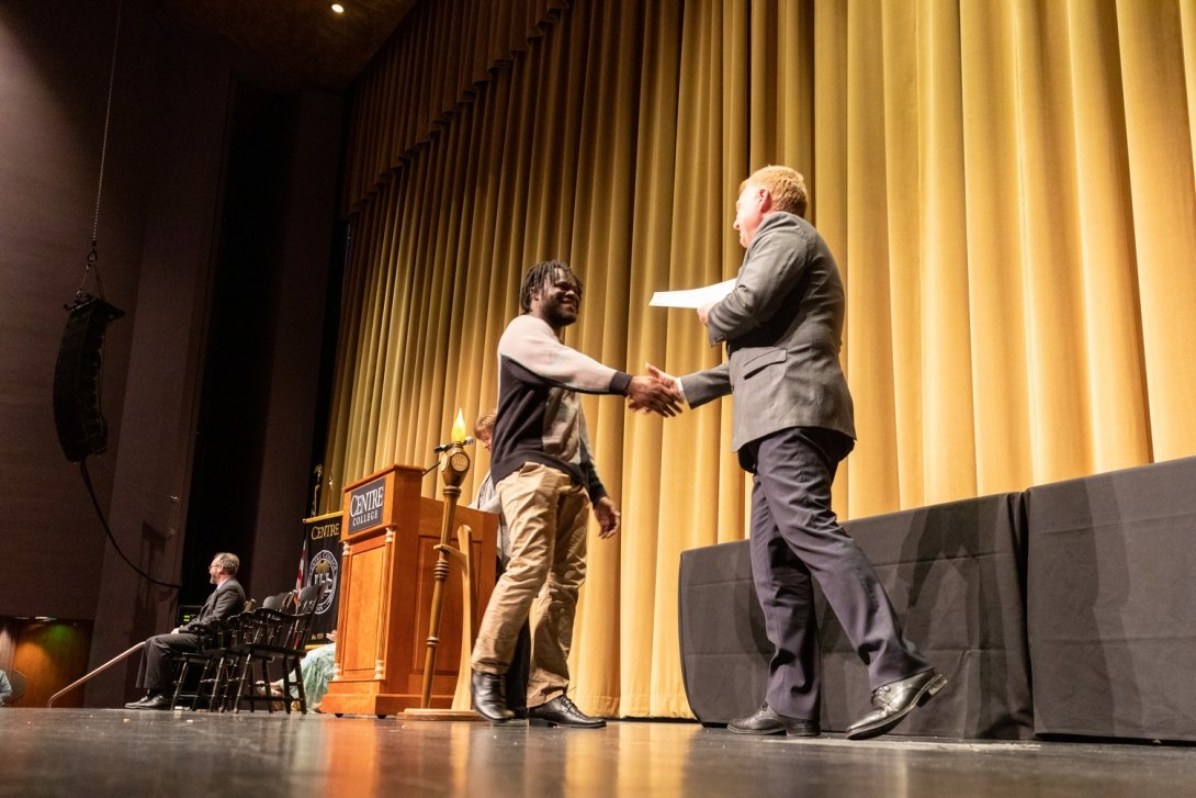 A student receives an award from President Milton Moreland at the 2023 Honors Convocation.