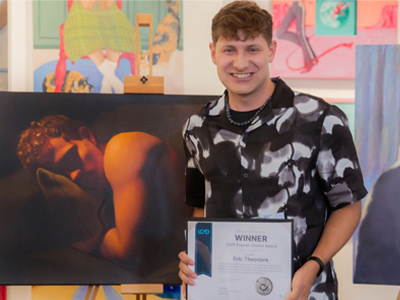 person smiling holding award