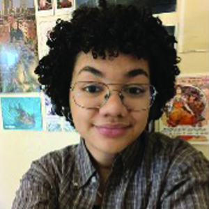 student wearing glasses and smiling at camera