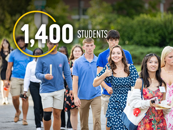 Group of students walking across campus. Text reads: 1,400 Students. 