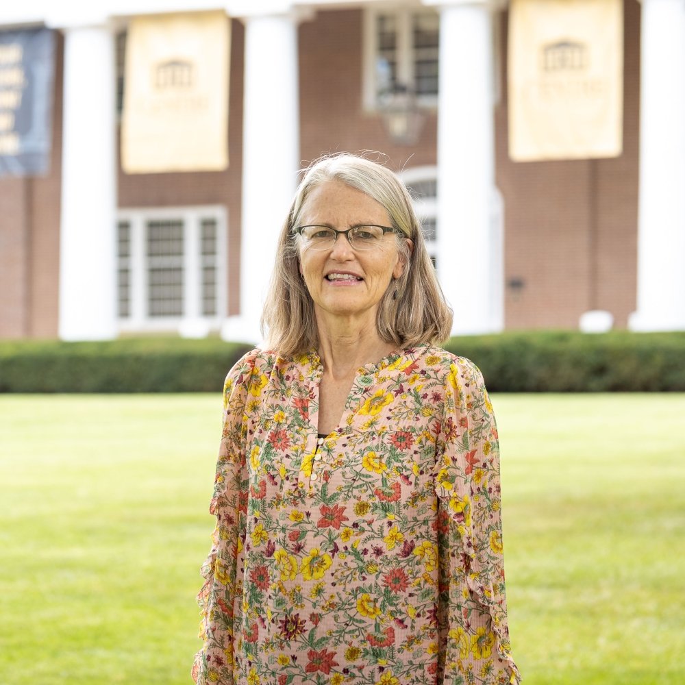 person smiling while standing in front of Old Centre