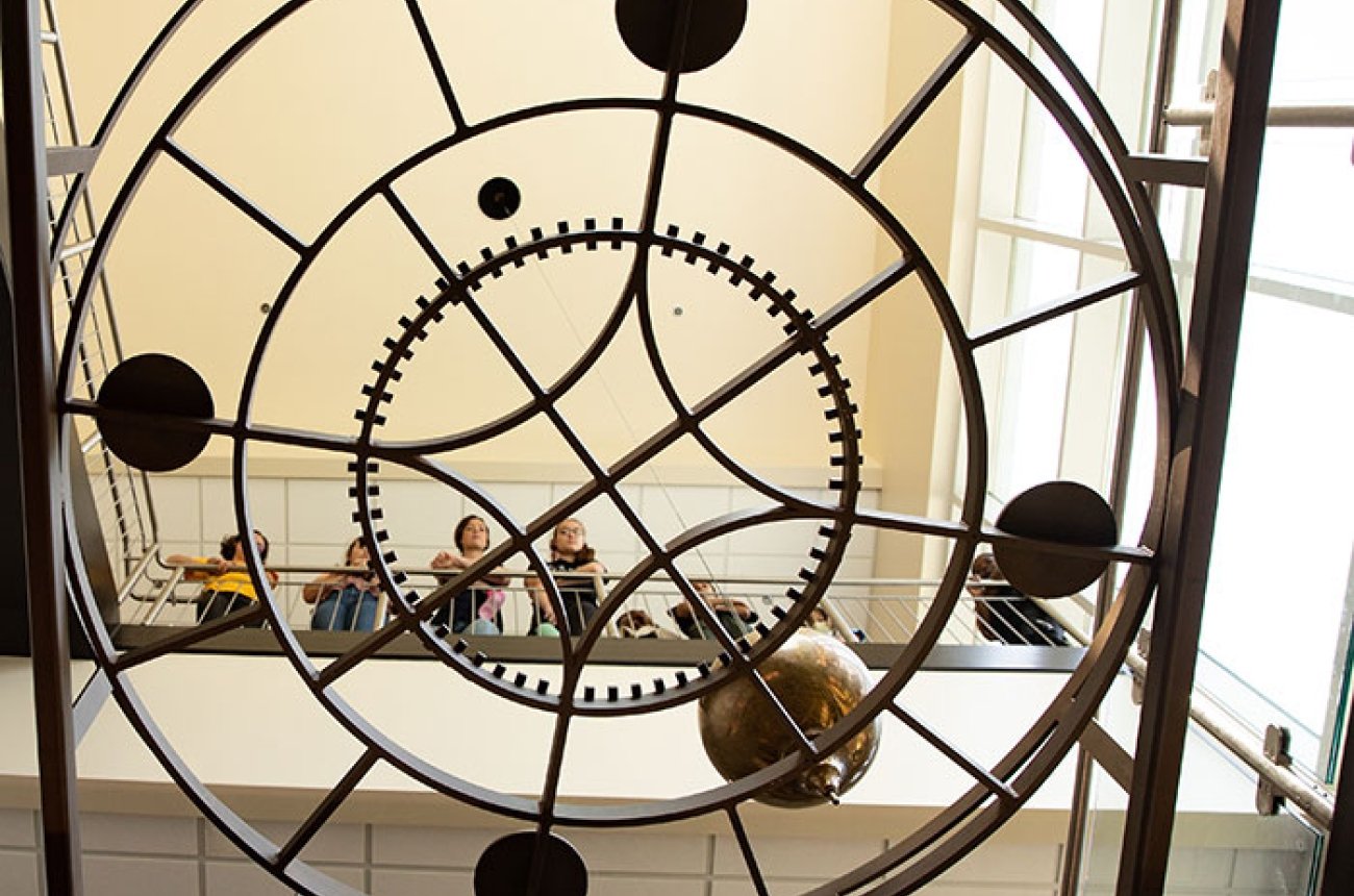 Students looking down through pendulum