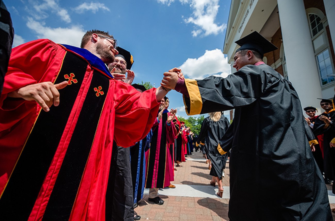 Graduate being congratulated by faculty