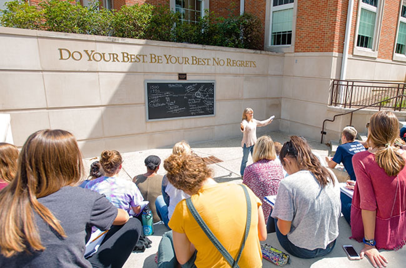 students listening to professor in outdoor classroom