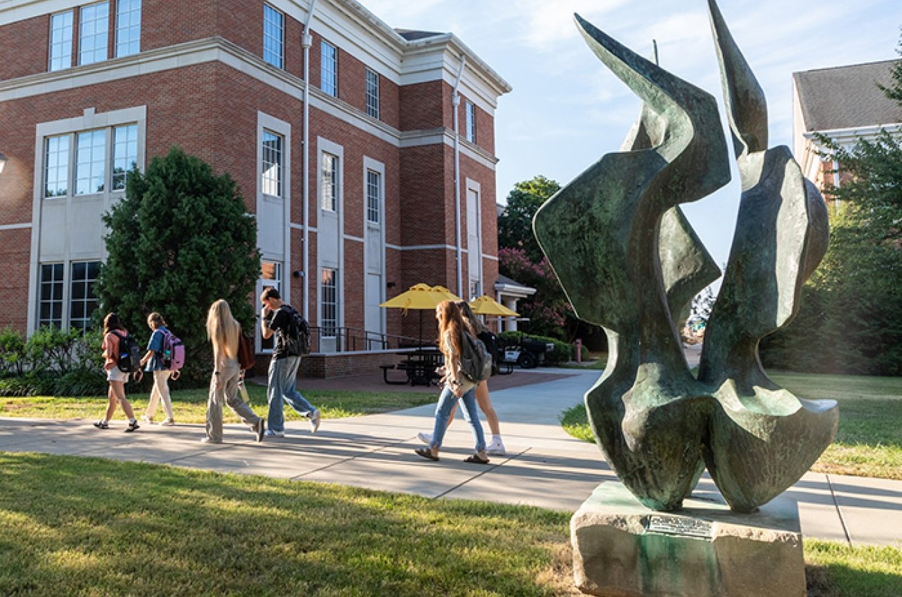 Students walking to class near the flame sculpture