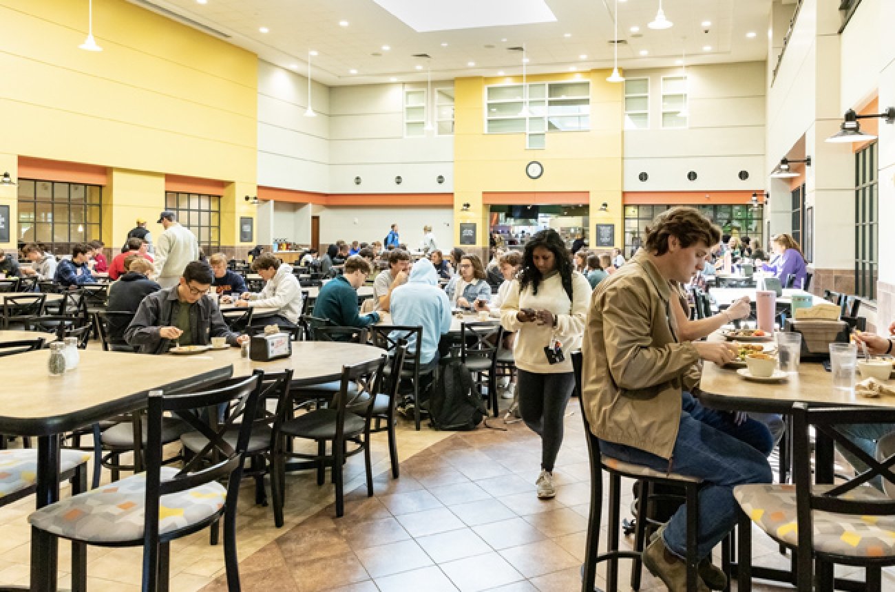 interior of Cowan Dining Hall large group of students sitting at different level of tables eating a meal