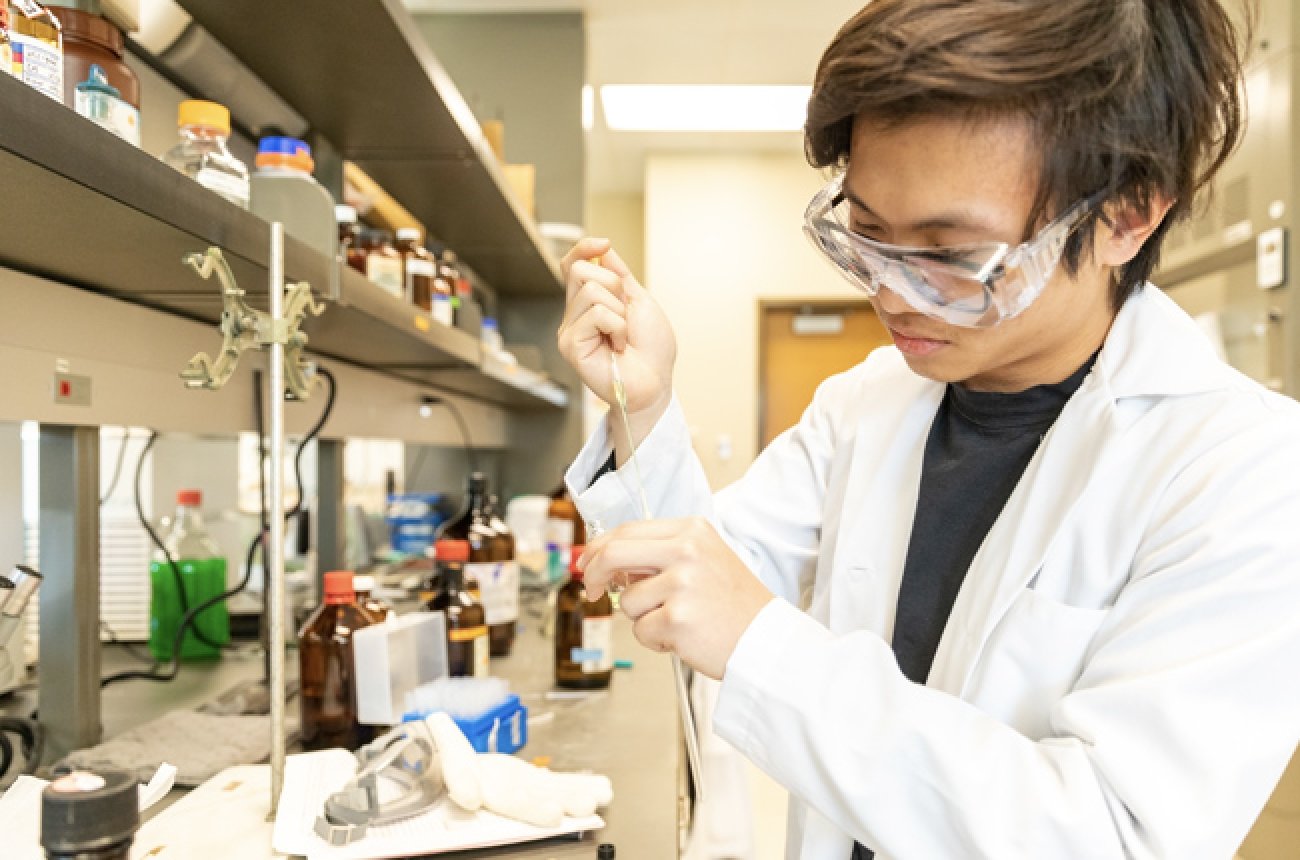 Student participating in chemistry lab doing experiment
