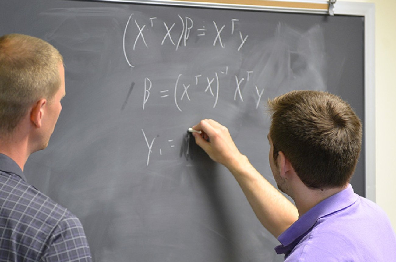 student working on math problem with Jeff Heath