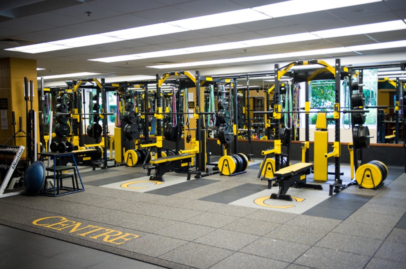 multi weight machines with accents in yellow inside Weight room in Buck Fitness Center