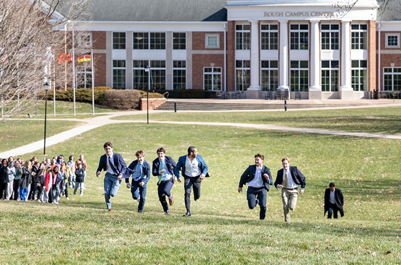 Students racing uphill in front of the Roush Campus Center