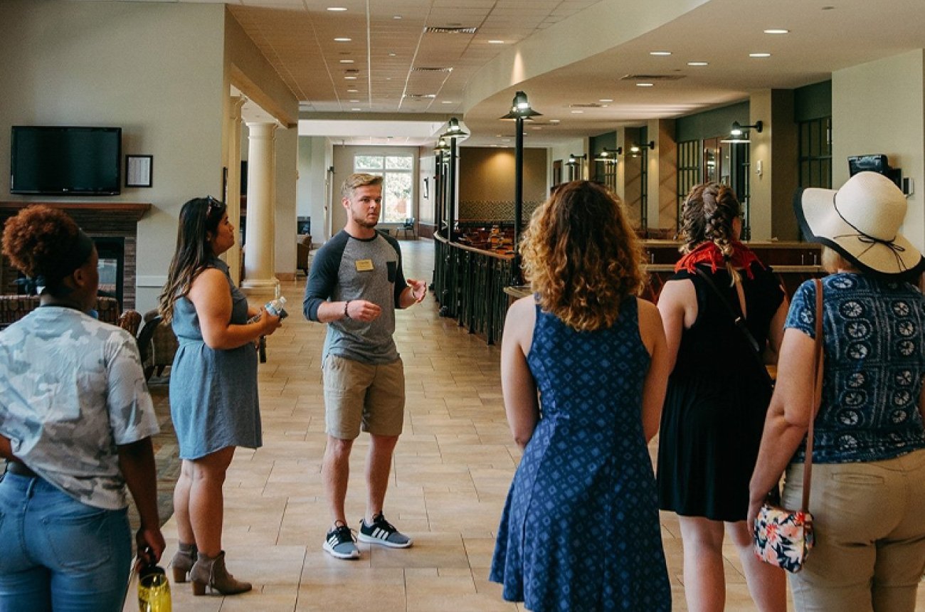 Group of parents and students listening to tour guide inside Roush Student Center