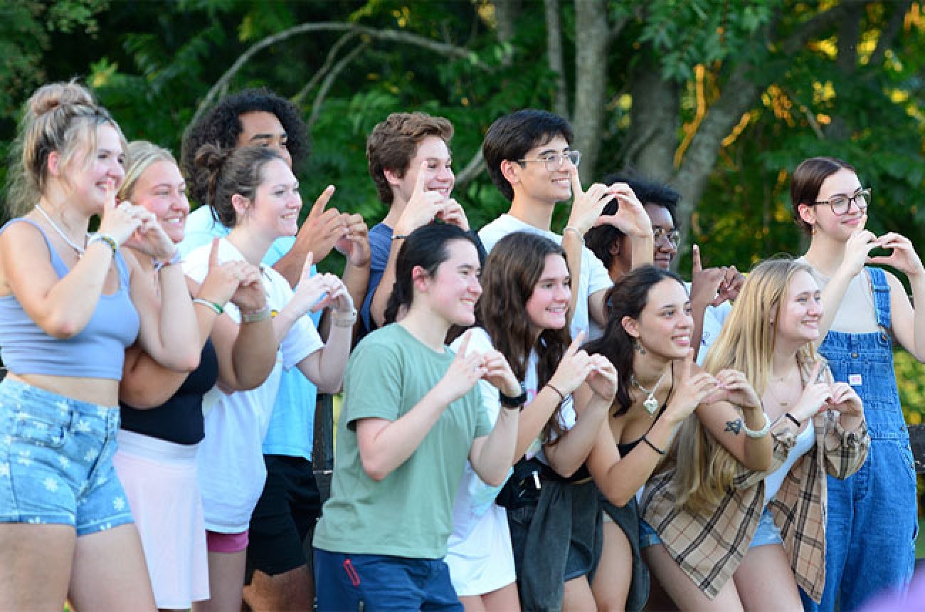 Group of students posing at camera making hearts with their hands