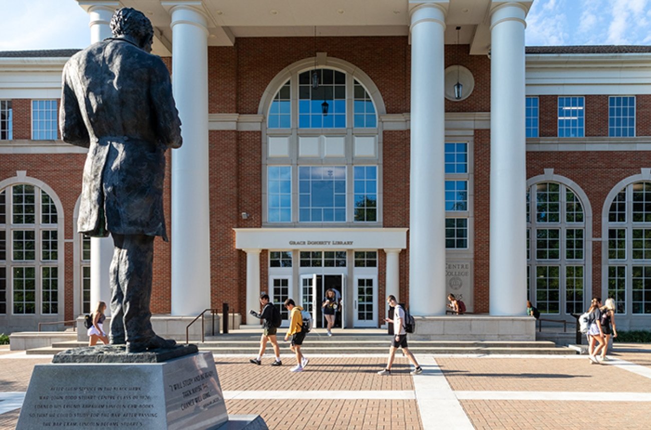 students walking on campus in front of the library