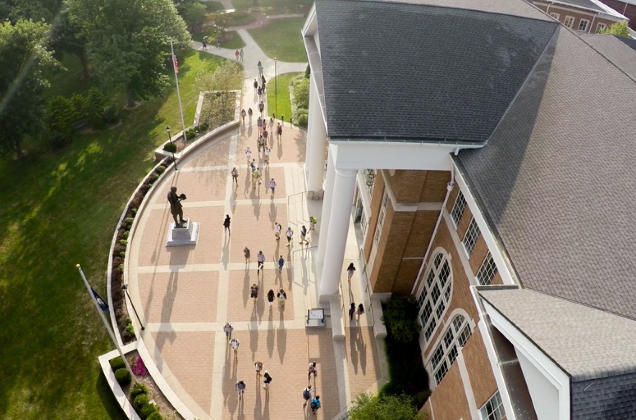 Students walking in front of the library on the way to class