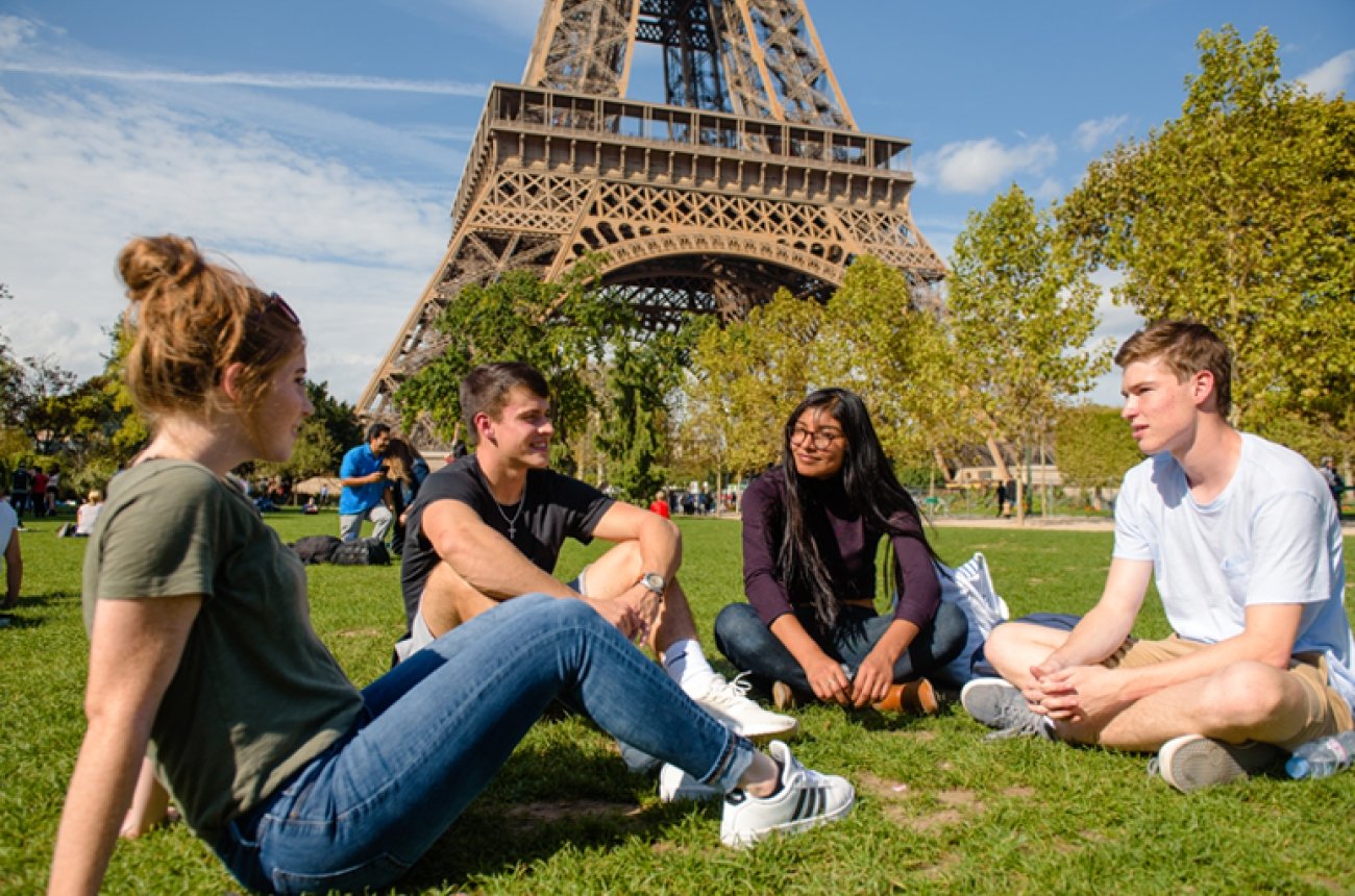 students sitting in front of the Eiffel Tower