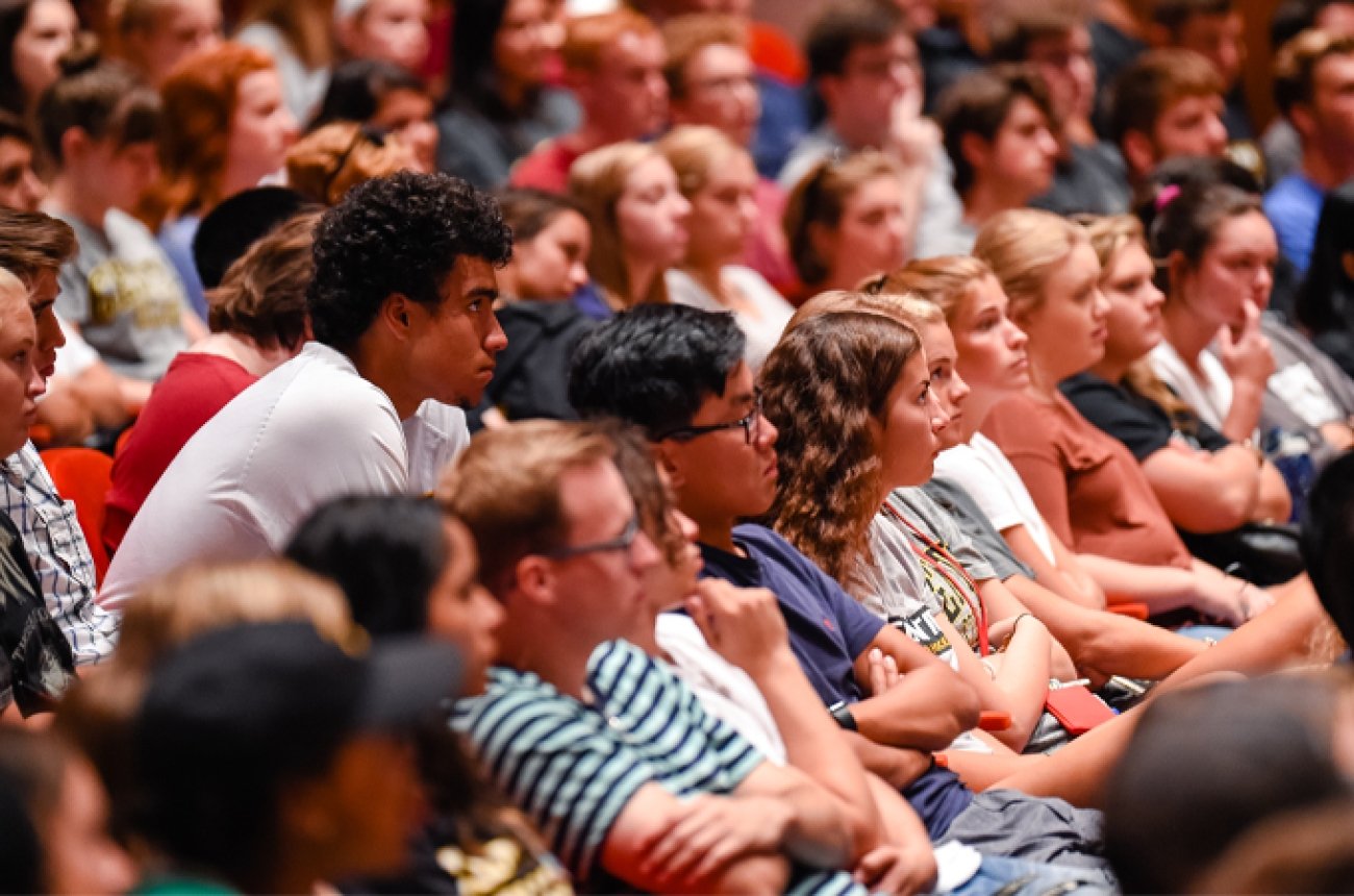 Large group of students sitting in Norton Center Newlin theatre listening to speaker