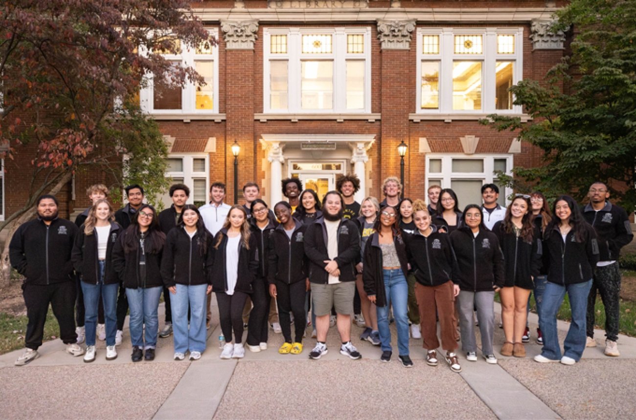 Group of students standing in front of Old Carnegie wearing Grissom jackets
