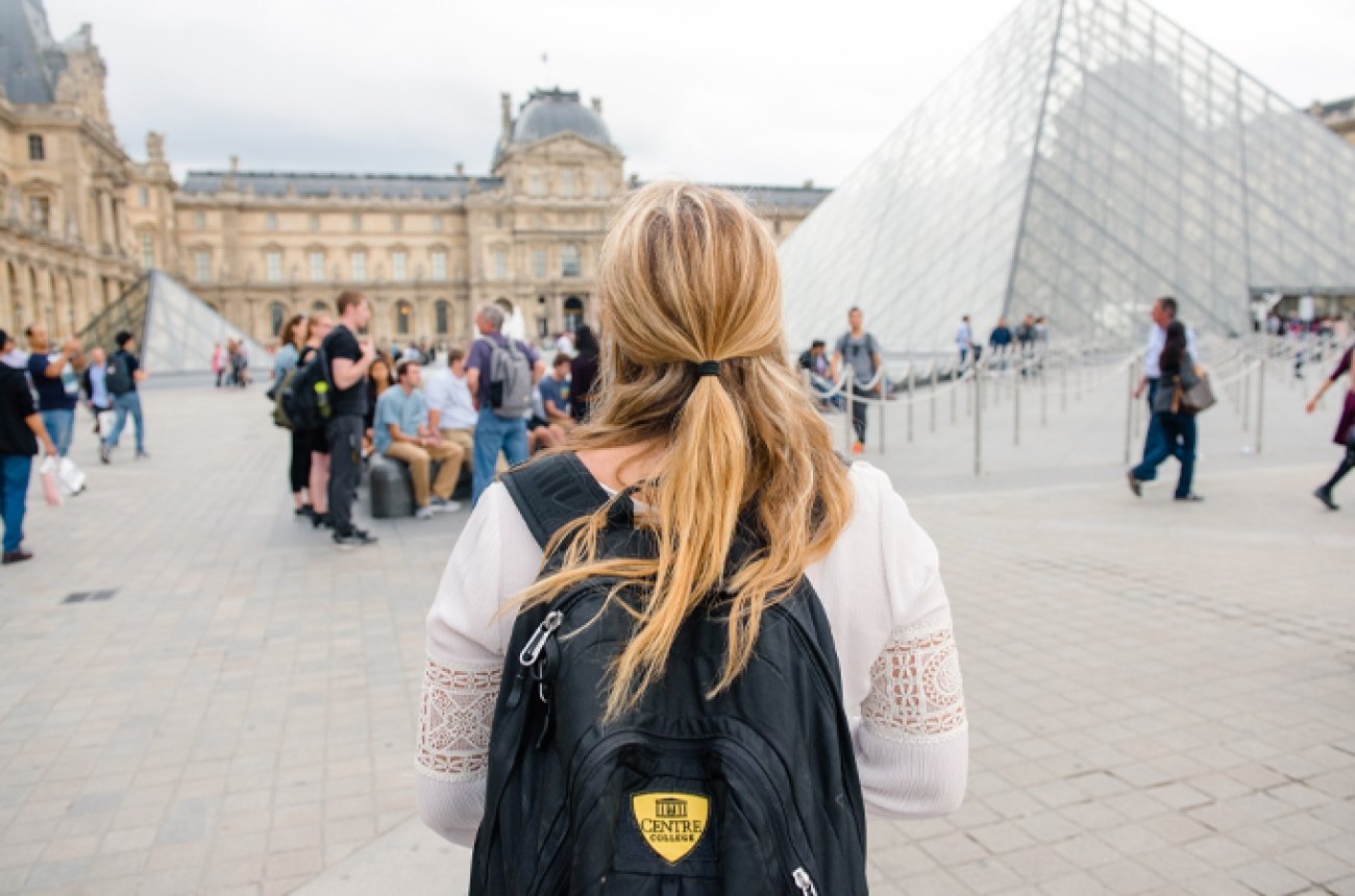 Student wearing Centre College backpack walking near the Louvre in Paris