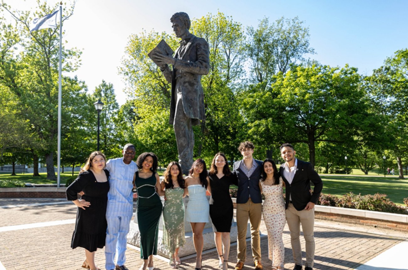 Group of students standing in front of Abraham Lincoln statue and smiling at photographer