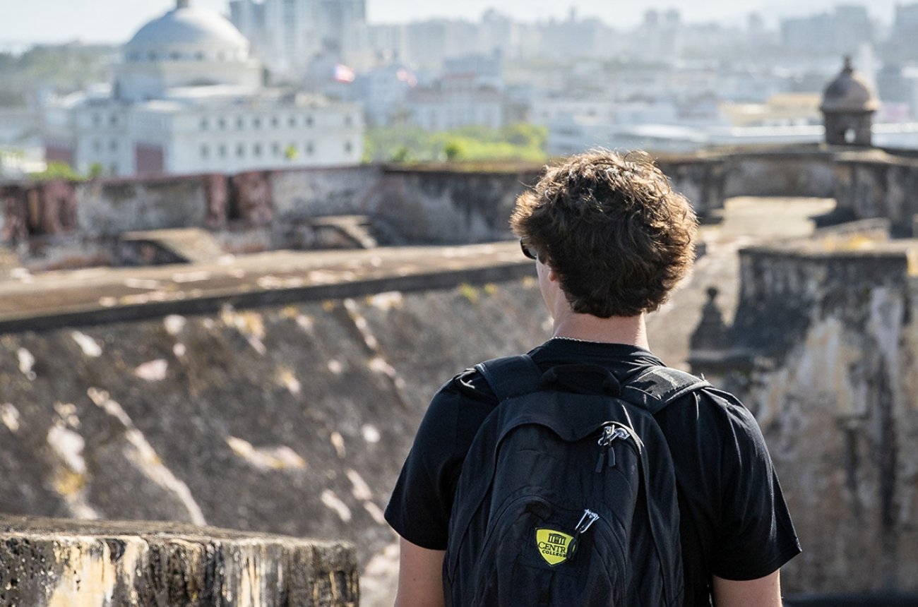 Student with backpack overlooking Puerto Rico skyline