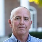 Person with light blue dress shirt standing in front of Old Centre
