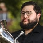 Man wearing glasses holding a euphonium music instrument