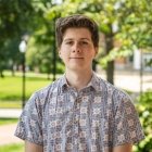 Person wearing button up dress shirt and smiling