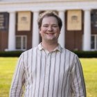 Person wearing striped dress shirt and smiling at camera