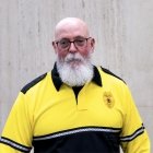 Person wearing glasses and gold and black polo with DPS badge on shirt