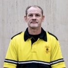 Person wearing gold and black polo top with DPS badge logo