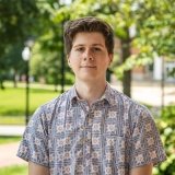 Person wearing button up dress shirt and smiling