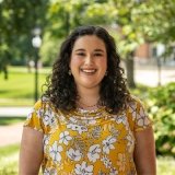 Person wearing yellow floral top and smiling at camera