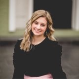 student wearing black top and pink pants