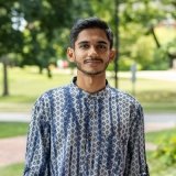 Person wearing patterned shirt and smiling at camera