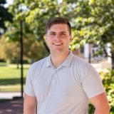 Person wearing polo shirt and smiling at camera