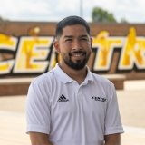 Person wearing white Centre logo Polo short sleeve and smiling at camera