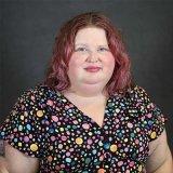 Person wearing colorful top and smiling at photographer