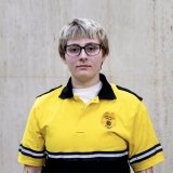 Person wearing glasses and gold and black polo with DPS badge on shirt