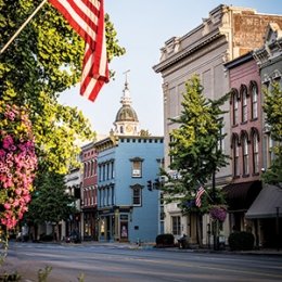 Main street downtown Danville with multi color buildings, American flag, trees lining main street