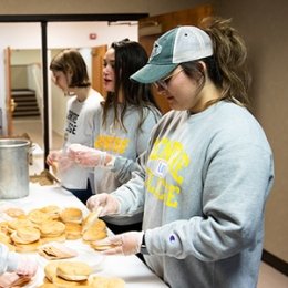 Centre students wearing Centre College grey sweatshirts assembling sandwiches at food pantry