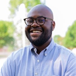 Aaron_Guerrier - man smiling wearing glasses and light blue dress shirt