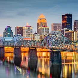 Downtown Louisville skyline at night with bridge and buildings lit up