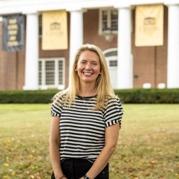 Lady with blonde shoulder link hair wearing black and white striped shirt in front of Old Centre