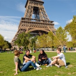 students sitting in front of the Eiffel Tower