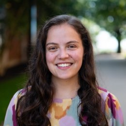 woman with long dark hair and paisley multi colored shirt